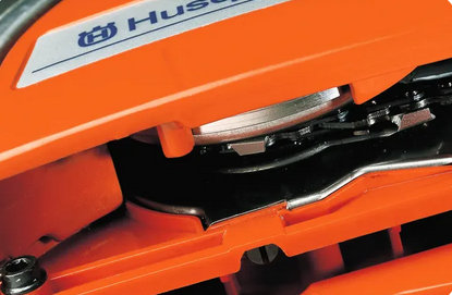 Nahaufnahme der Fliehkraftkupplung und der Kettenbremse unter dem Gehäusedeckel einer Husqvarna Säge.