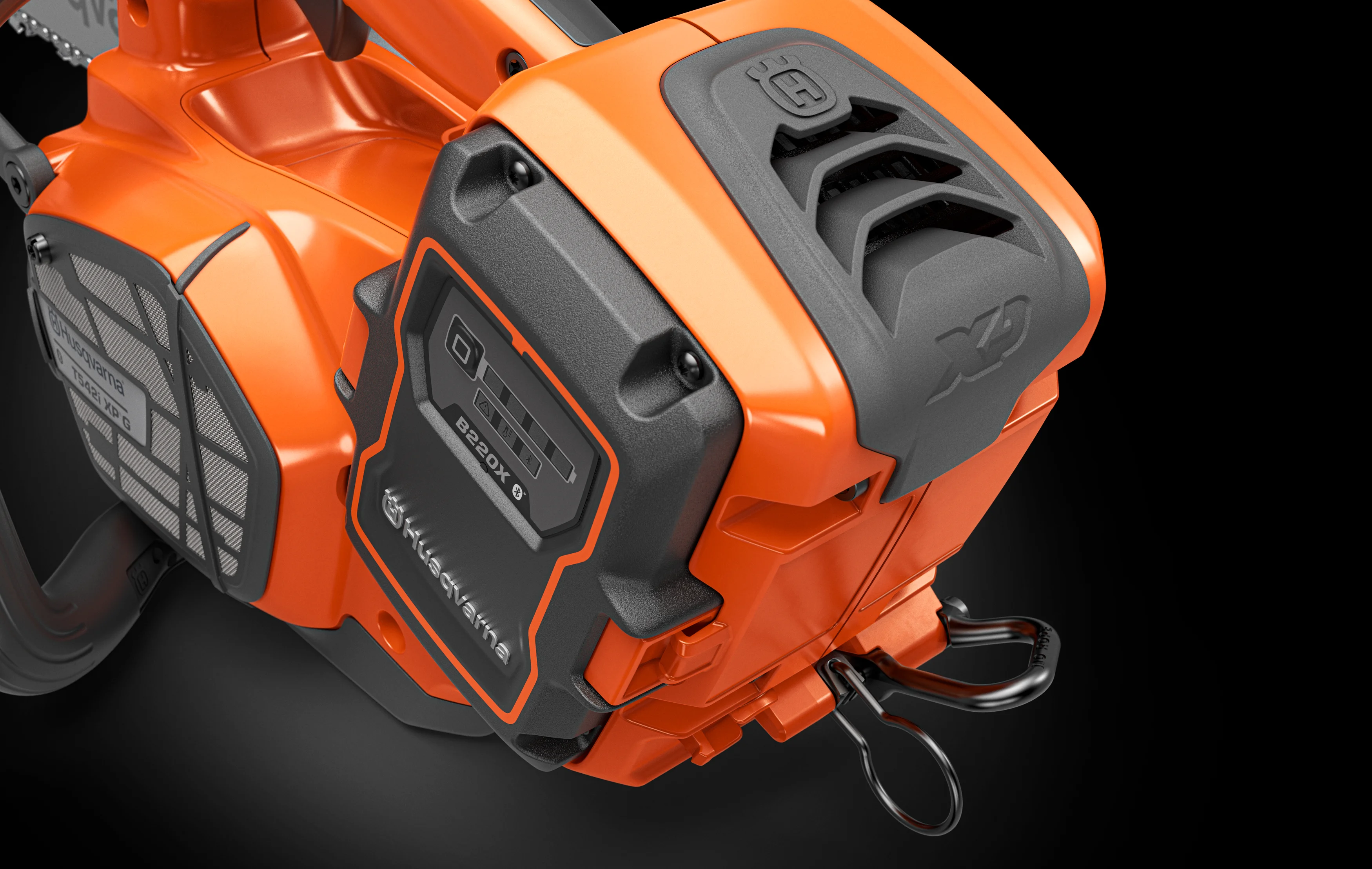 Detailansicht der Gehäuserückseite einer Husqvarna T542i XPG mit eingesetztem B220X-Akku, Ösenaufhängung und XP-Schriftzug.