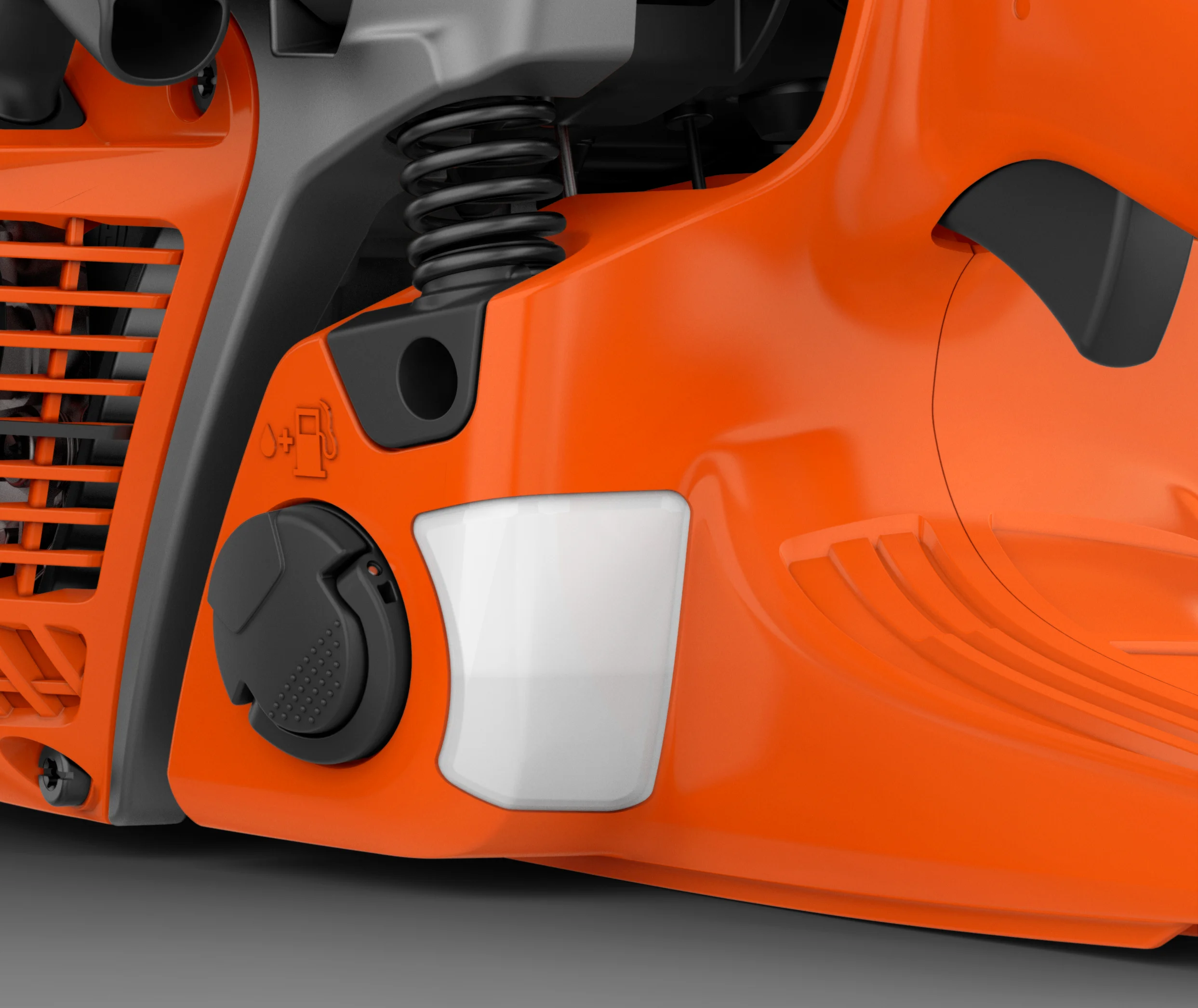 Detailaufnahme der Gehäuseunterseite einer Husqvarna Motorsäge mit Klapp-Tankdeckel, Füllstandsanzeige und Dämpfungsfeder.